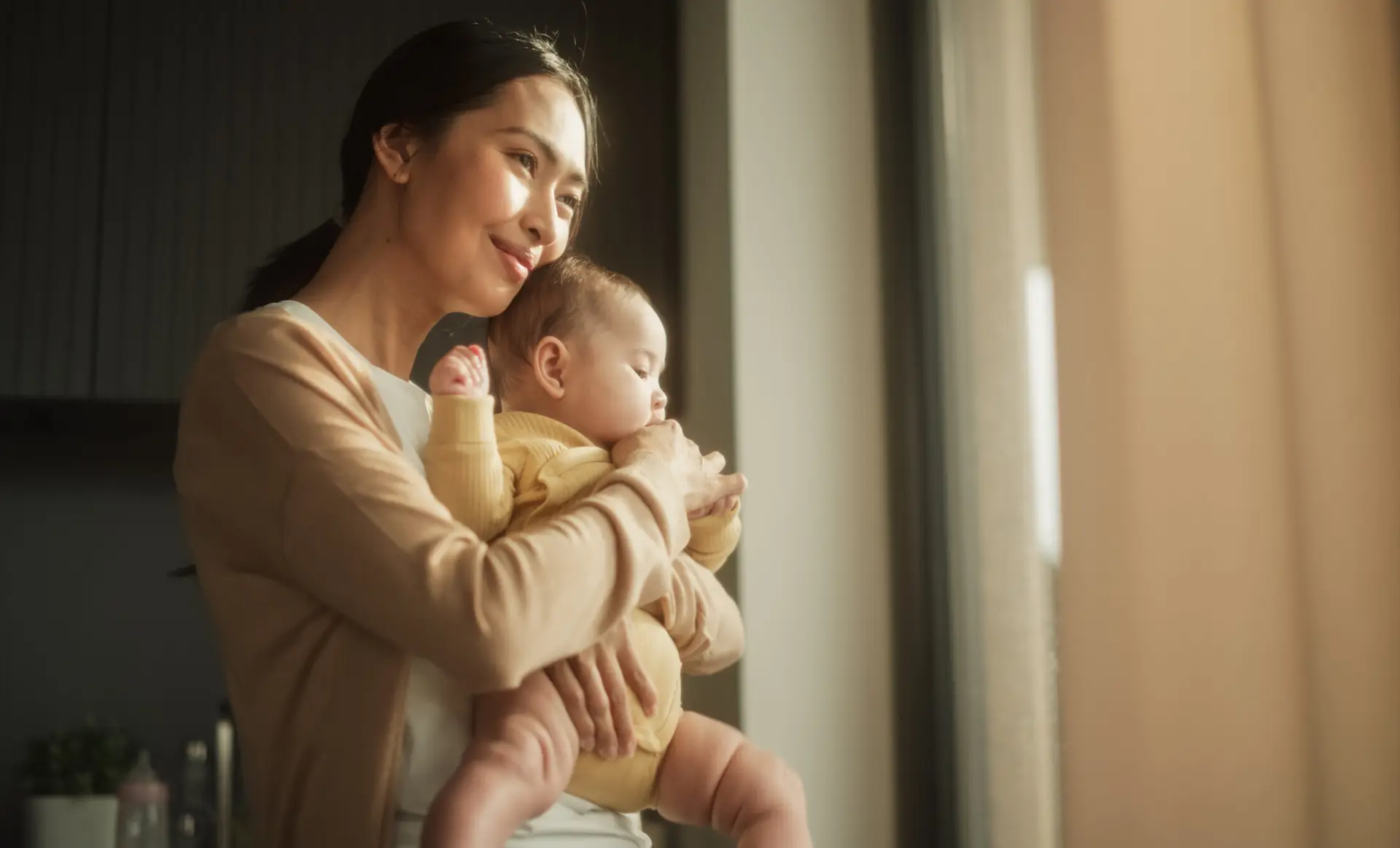 Happy Woman, New to Motherhood, Embracing her Child and Enjoying the Bonding Moment Together